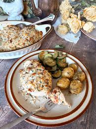 Hot Neiman Marcus Chicken Casserole with golden brown topping, served in a baking dish with visible melted cheese and bacon.
