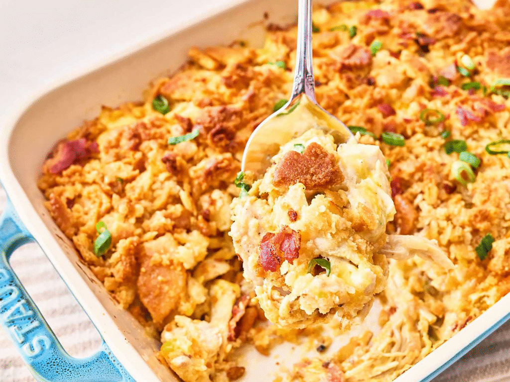 Close-up of a golden-baked Neiman Marcus Chicken Casserole topped with buttery cracker crumbs, melted cheese, and crispy bacon pieces in a white baking dish.