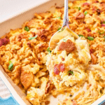 Close-up of a golden-baked Neiman Marcus Chicken Casserole topped with buttery cracker crumbs, melted cheese, and crispy bacon pieces in a white baking dish.